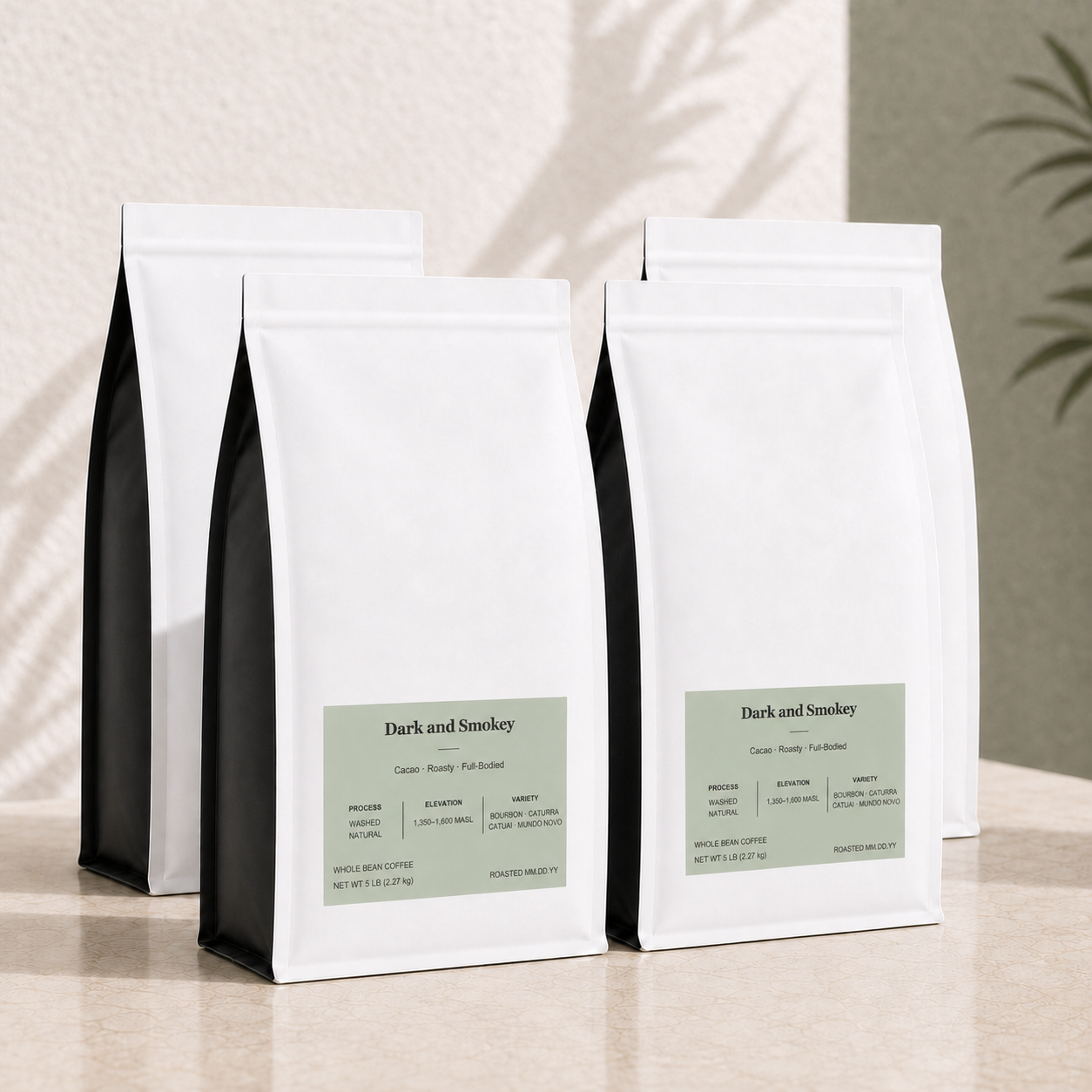 Four white bulk 5 lb coffee bags with black side panels and pale green labels, arranged on a beige surface against a textured wall with soft shadow overlays. The front bags show the text "Dark and Smokey" 