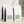 Four white bulk 5 lb coffee bags with black sides and a muted sage green label reading 'Guatemala Yula' on a light beige surface against a textured beige wall with soft leaf shadows.