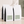 Four white bulk 5 lb coffee bags with black side panels and pale sage green labels, arranged on a light beige surface against a softly textured beige wall with leaf shadows. Kenya Kiamugumo