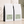 Two white bulk 5 lb. coffee bags with black side panels and pale green labels, arranged on a beige surface against a textured wall with soft shadow overlays. For The 50/50 blend.